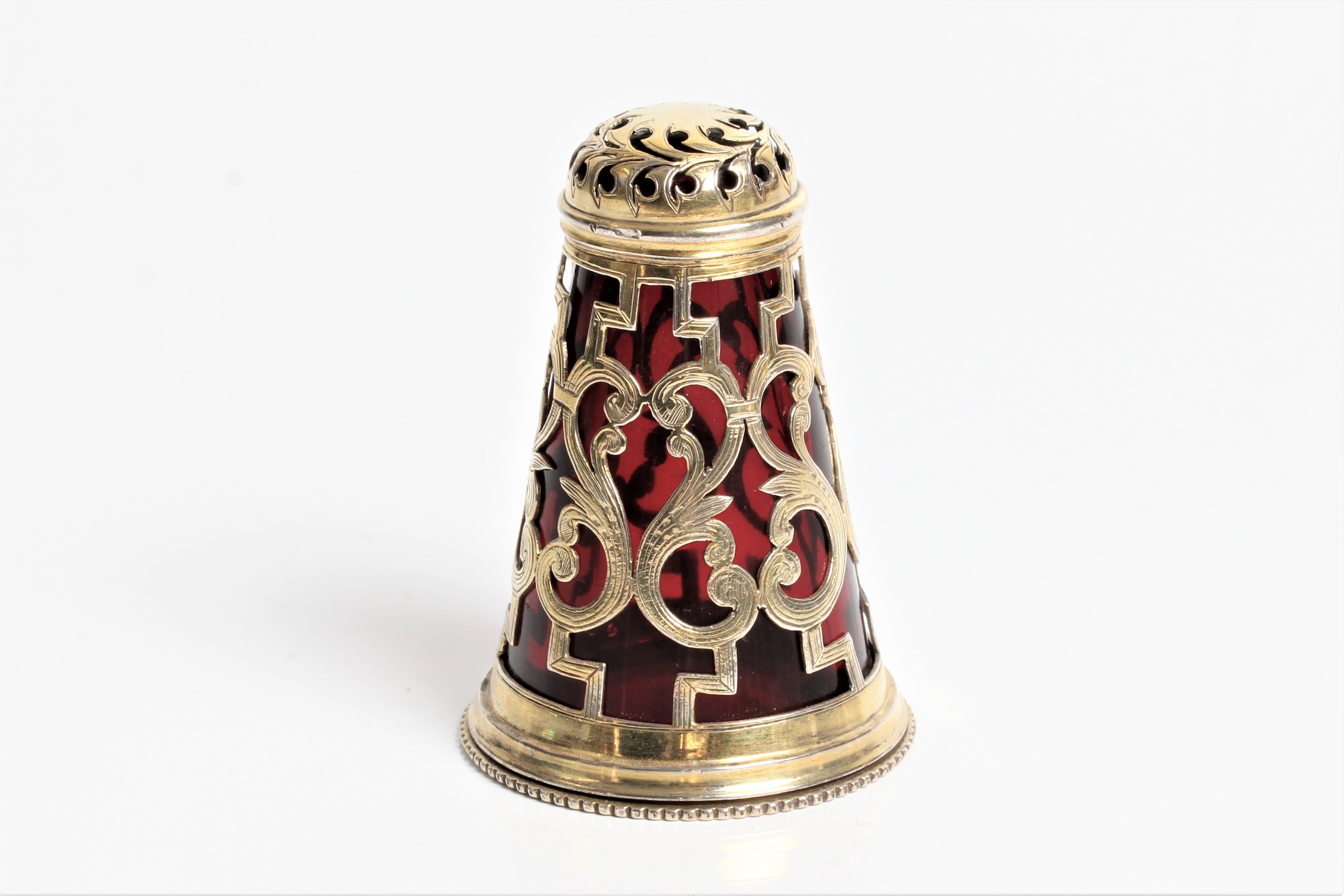 A Victorian silver pepper pot with red glass liner and screw base with marks for London 1850 and