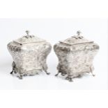 A pair of George IV silver decorative tea caddies with rose finials, ornate floral decoration to