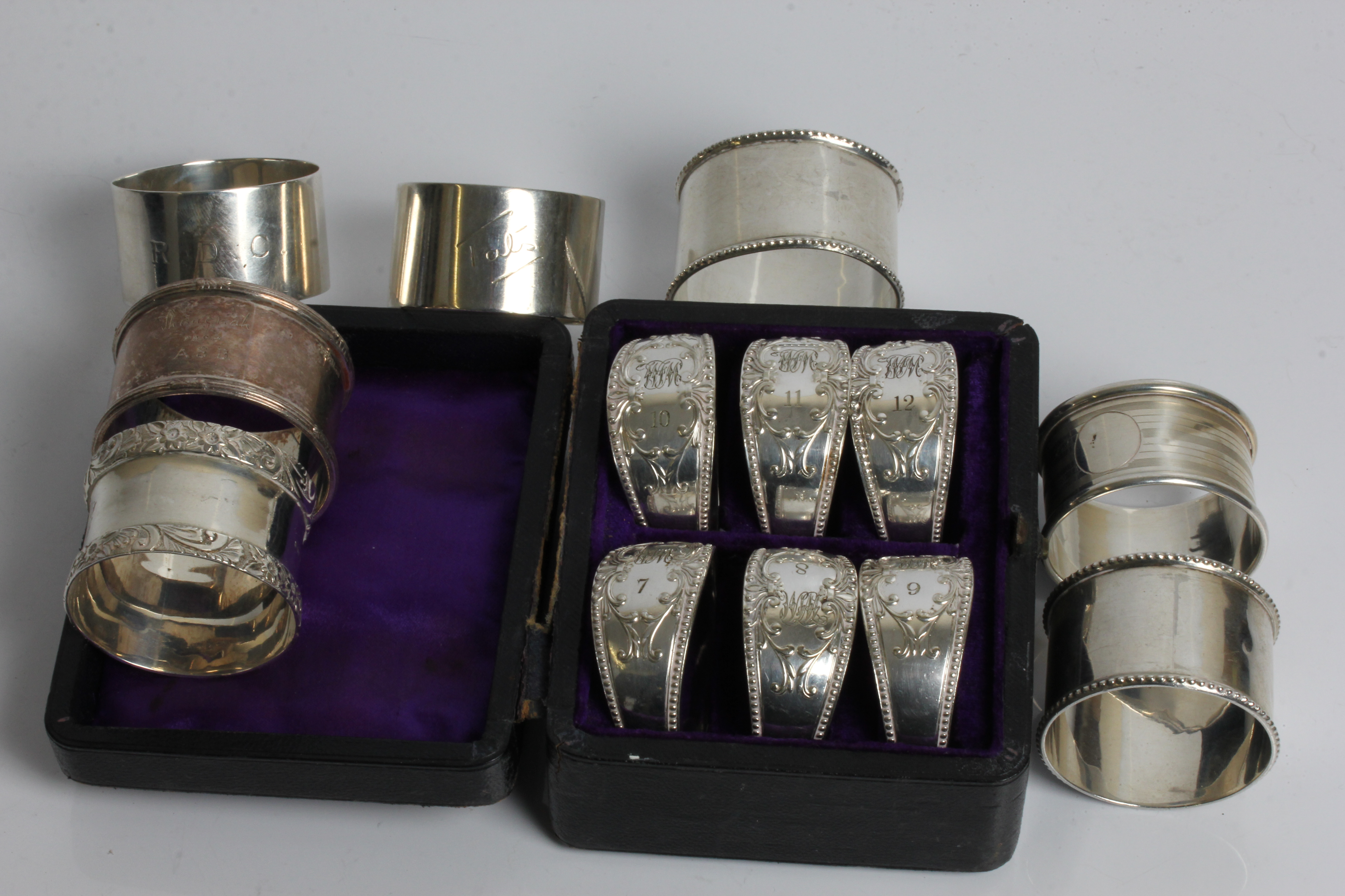 Seven various silver napkin rings, with a set of six napkin rings engraved 'WJM' and 7-12, in