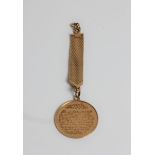 A yellow gold medallion featuring Arabic writing, marked 18ct gold, approx. weight 15.9gms.