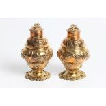 A George II pair of silver gilt tea caddies of decorative baluster form with embossed and chased