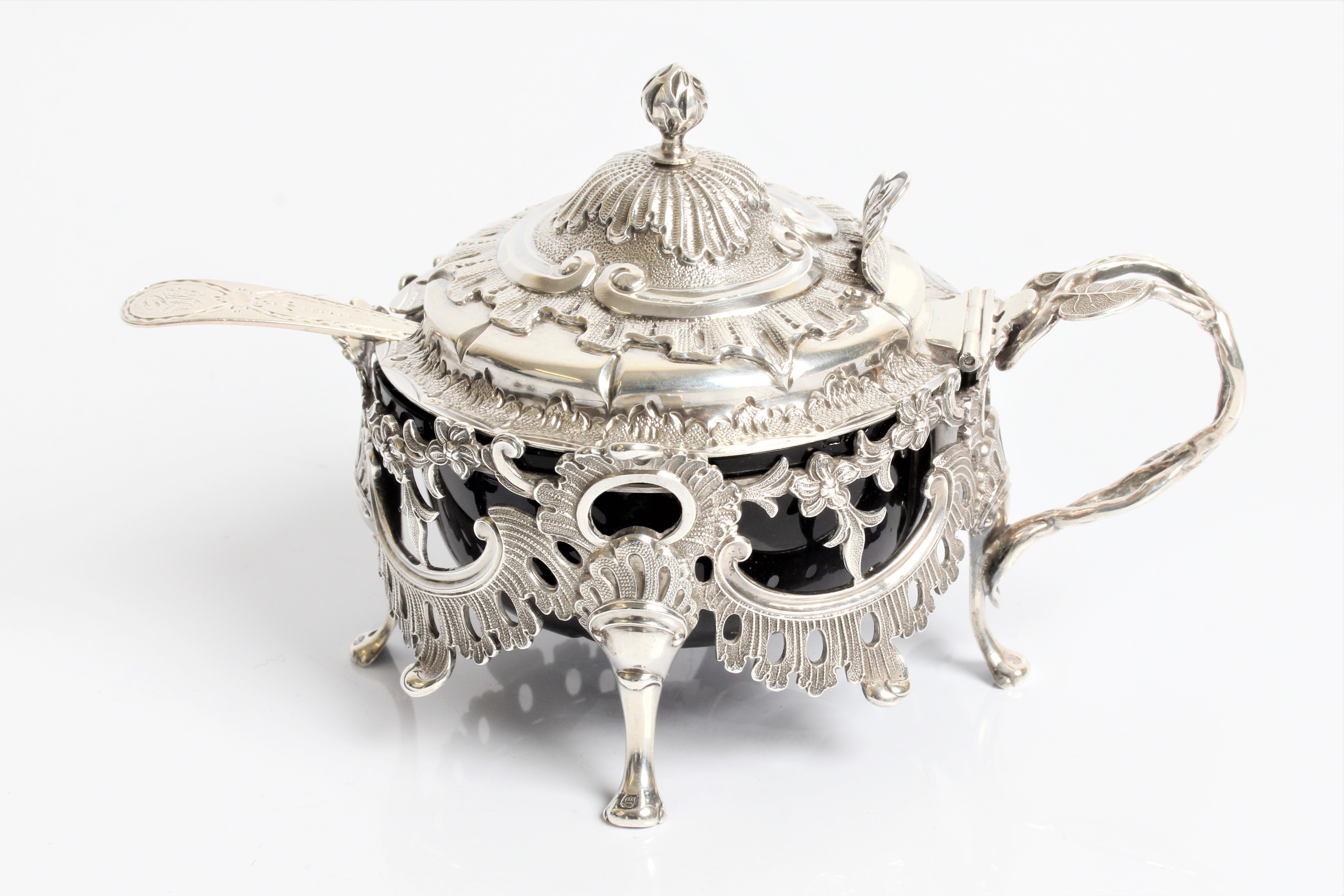 A silver early Victorian salt pot with decorative hinged lid and fret work body on four cabriole