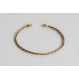 A yellow gold twist design torque bangle, marked 18ct gold, approx. 7.5gms. Important: Online