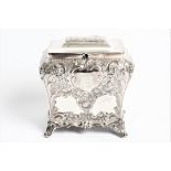 A Victorian silver decorative tea caddy with lock, shapped body with four feet and shield engraved