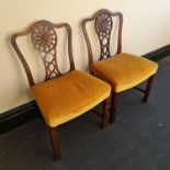 A pair of early 19th century mahogany chairs with carved flower design backs. IMPORTANT: Online