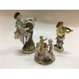 Three Meissen figures, four cherubs around fire, man with wine barrel (restored), man playing viola,