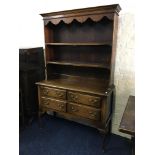 An oak four drawer dresser on cabriole support.