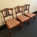 A set of six 19th century rosewood dining chairs with turned and fluted front legs and carved leaf