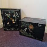 A black painted oriental style blanket box and two door cupboard, both with red headed cranes and