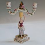A Meissen two arm candlestick holder, with female carrying basket on head forming the stem, marked