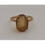 A single yellow stone dress ring, set with an oval cut yellow stone measuring approx. 12x9mm,