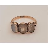 A three stone moonstone ring, set with three graduated moonstone cabochons, stamped 9ct, ring size