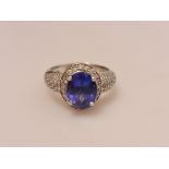 A hallmarked 18ct white gold tanzanite and diamond ring, set with a central oval cut tanzanite,