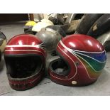 Six crash helmets, including two custom candy red helmets, with four vintage helmets and visors,