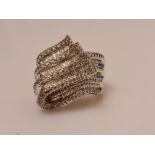 A hallmarked 9ct yellow gold diamond dress ring, the fold over design set with seven rows of
