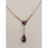 An amethyst and seed pearl drop necklet, set with a pear cut amethyst suspended from a round cut