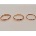 Three plain wedding bands, two hallmarked 22ct weighing approx. 4.4g and the other unmarked yellow