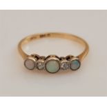 An opal and diamond five stone ring, set with alternating round opal cabochons and single-cut