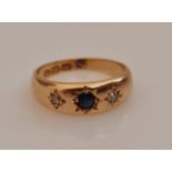 A hallmarked 18ct yellow gold sapphire and diamond three stone ring, star set with a central