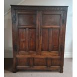 A late 17th century oak two door clothes press with carved freeze above door inscribed ‘1694’ and ‘