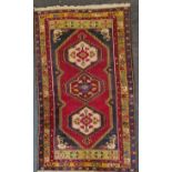 A large Afghan rug with three medallion central design, blue and burnt orange border, 213cm x 107cm.