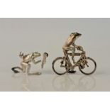 Two novelty silver frog ornaments, one with bunch of flowers and crown, the other riding a bicycle,