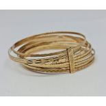 A hallmarked 9ct yellow gold multi-bangle bracelet, each bangle engraved with different geometric