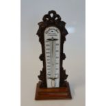 A Chadburn & son Liverpool desktop mercury barometer, with a carved oak floral frame. 31cm.