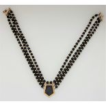 A black hardstone bead necklace, featuring a central panel of black hardstone, length approx.