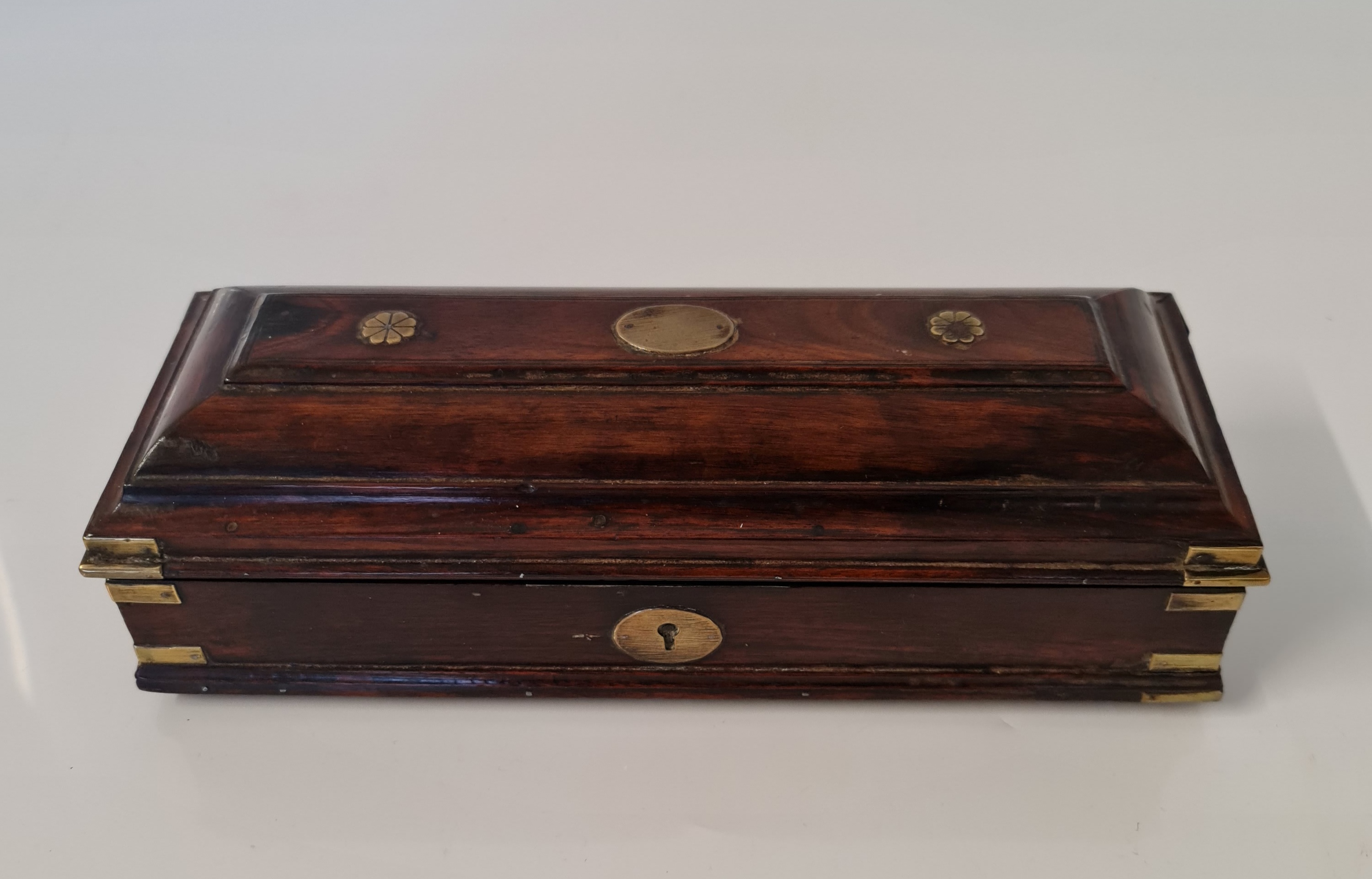 An early 19th century mahogany travel inkwell with brass corner mounts and detail to top, approx.