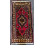 An large Afghan rug with red central diamond, beige and blue border, 223cm x 106cm. IMPORTANT: