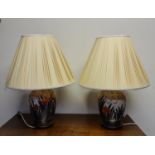 A pair of Chinese style lamps, with iris designs to base and cream pleated shades, heights of