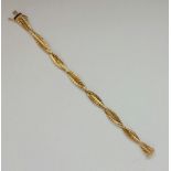 A fancy cross over three strand bracelet, stamped 585, length approx. 19cm, weight approx. 20.6g.