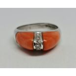 A hallmarked 14ct white gold coral and diamond dress ring, set with two panels of coral leading to a