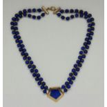 A lapis lazuli bead necklace, featuring a central panel of lapis lazuli, stamped 375, length approx.