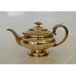 A George IV silver teapot, of squat form with reeded rim, foliage design to handle and finial,