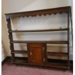 An 18th century oak wall plate rack, with central cupboard. IMPORTANT: Online viewing and bidding