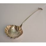 A silver George III ladle of shell design with scroll top handle, hallmarked London, date possible