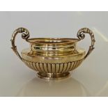 A George IV silver sugar bowl, of squat form with gadrooned body and scrolling handles, engraved