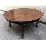A solid oak round wind out dining table on four Queen Anne style legs with three spare leaves.
