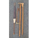 Two folk art walking sticks, one with carved head of boxer dog, horse riding crop, and a birch
