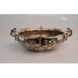 A Victorian silver dish, of oval form with repousse floral desing and four scrolling handles,