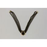 A black hardstone bead necklace, featuring a central panel of black hardstone, length approx.