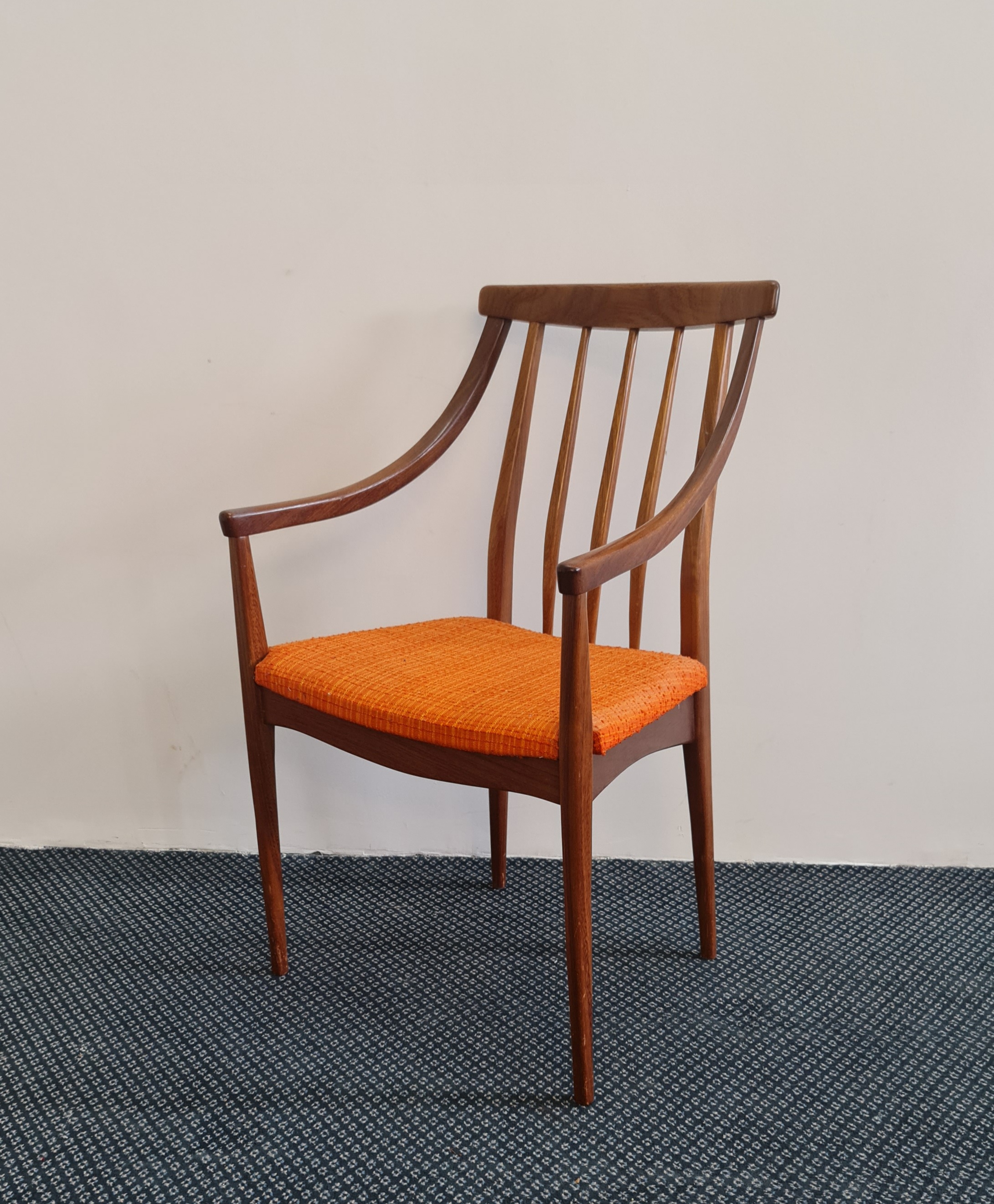 *A teak mid century design carver armchair with orange upholstered seat. IMPORTANT: Online viewing