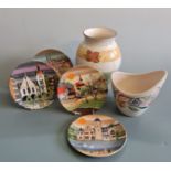 Two Poole Pottery vases, with four Poole small wall plates with urban building scenes. IMPORTANT: