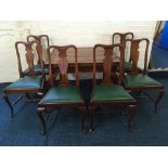 A mahogany drawer leaf dining table on Queen Anne style legs with a set of matching green