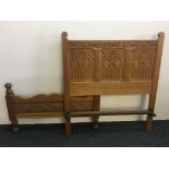 A Frank Watt Derby heavily carved oak Gothic style single bed frame headboard and footboard.