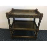 An oak two tier drinks trolley with turned columns. IMPORTANT: Online viewing and bidding only.