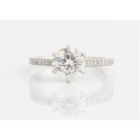 A hallmarked platinum diamond ring, set centrally with a principal round brilliant cut diamond,