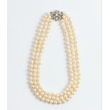 A three row string of cultured pearls with diamond flower design clasp, pearls measure approx.